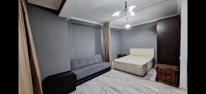 a small room with a bed and a couch at Next Level in Poti