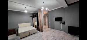 a bedroom with a bed and a flat screen tv at Next Level in Poti