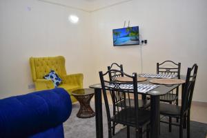 ナクルにあるFaisha 1bedroom Near Sarova Woodlandsのリビングルーム(テーブル、椅子、ソファ付)