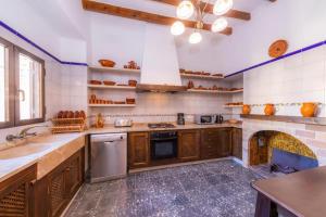 a kitchen with a sink and a stove top oven at Villa S`Alzina by Slow Villas in Santanyi +22 photos