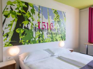 1 dormitorio con una gran pintura encima de una cama en B&B Hotel Ingolstadt, en Ingolstadt