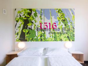 - une chambre avec 2 lits et un tableau mural dans l'établissement B&B Hotel Ingolstadt, à Ingolstadt