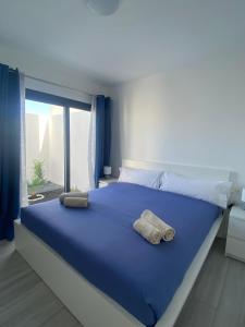 a bedroom with a large blue bed with a window at Villa Sol Fuerteventura in La Oliva