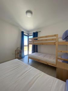 a bedroom with two bunk beds and a window at Villa Sol Fuerteventura in La Oliva