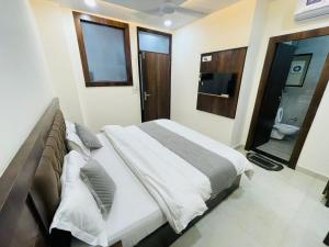 a bedroom with a large bed and a bathroom at Divine Ganga by MJ Hospitality in Haridwār