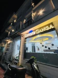 una moto parcheggiata di fronte a un ristorante dmgarmaarma di notte di Divine Ganga by MJ Hospitality a Haridwār