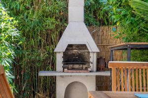 a outdoor oven with a roof with a fence at Villa Gardenia in Premantura