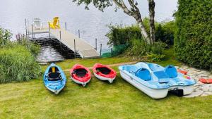 three boats sitting on the grass next to a dock at Chalet KLS Lac D'Argent in Eastman