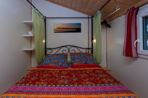 a bedroom with a bed with a colorful bedspread at Les chats perchés 400m plage D in Labenne