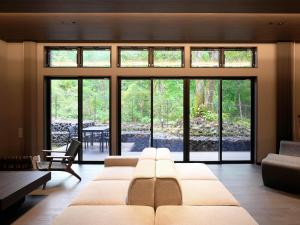 a living room with a large couch and glass windows at Rakuten STAY VILLA Nikko in Nikko