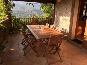 - une table et des chaises en bois sur une terrasse avec vue dans l'établissement Villa 4* Piscine chauffée, à Sotta