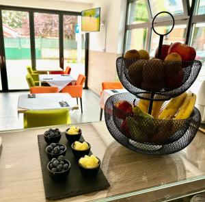 a basket of fruit on a table with bowls of fruit at Hotel National in Zagreb