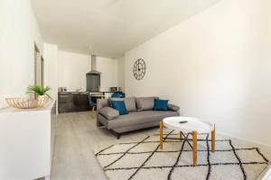 a living room with a couch and a table at LE BLEU - Lumineux, 1 chambre, salle de bain moderne in Castelsarrasin