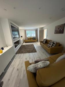 sala de estar con 2 sofás y sofá en Garreg Fawr Trearddur Bay - Ty Melyn, en Trearddur