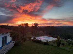 una puesta de sol sobre una piscina en un patio en Casa Azul, en Vila de Rei