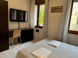 a bedroom with a bed and a flat screen tv at Albergo Roma in Valdagno