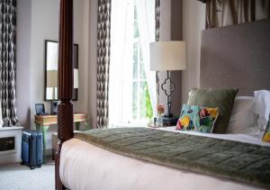 a bedroom with a large bed with a large window at Queens Hotel Cheltenham in Cheltenham
