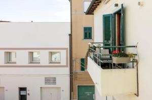 - un balcon avec des chaises et des fleurs dans un bâtiment dans l'établissement Vuotopieno Casa Blue Maremma, à Orbetello