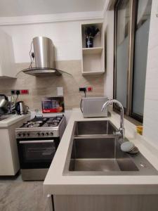 a kitchen with a sink and a stove at 2 Bedroom in Kilimani Ngong Rd in Nairobi