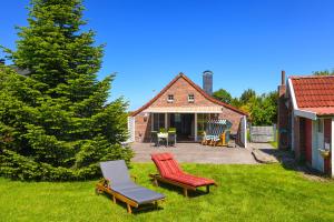 a yard with two lawn chairs and a house at Ferienhaus Sternenklar in Wittmund