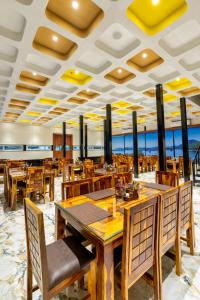 comedor con mesas y sillas de madera en The Grand Fateh, en Udaipur