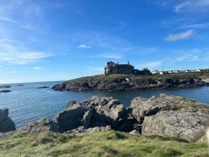 una casa en la cima de una isla en el océano en Garreg Fawr Trearddur Bay - Ty Melyn en Trearddur