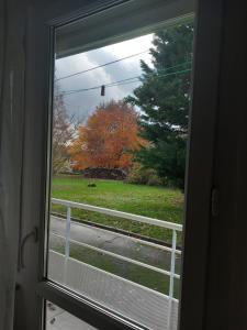 una ventana con vistas a un patio con una valla blanca en Les Églantines, en Luxeuil-les-Bains