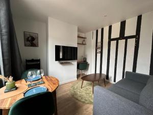La place d'Henri, Rouen centre في رووين: غرفة معيشة مع أريكة وطاولة