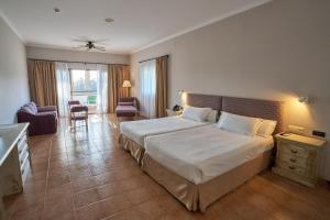 um quarto de hotel com uma cama grande num quarto em Hotel Alhaurín Golf Resort em Alhaurín el Grande