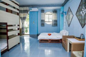 a blue room with a bed and a sink at Bụi Hostel - Bến Tàu Rạch Giá in Rạch Giá