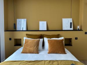 Bett mit weißer Bettwäsche und Kissen in einem Zimmer in der Unterkunft La place d'Henri, Rouen centre in Rouen