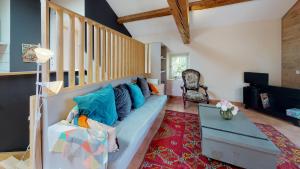 sala de estar con sofá azul y escalera en Domaine Paul Huc, en Fabrezan