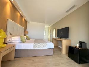 a bedroom with a bed and a flat screen tv at Hotel Revellata in Calvi