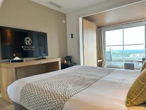 a hotel room with a bed and a flat screen tv at Hotel Revellata & Spa in Calvi