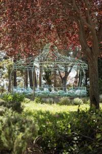 a white gazebo in the middle of a park at Boutique Hotel - Poggio ai Santi in San Vincenzo