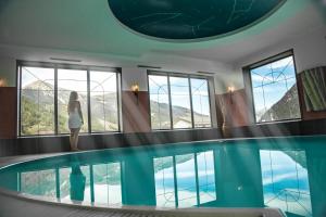 Eine Frau, die vor einem Schwimmbad steht. in der Unterkunft Wellnesshotel Liun B&B in Müstair