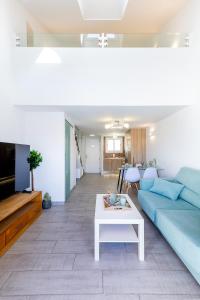 ein Wohnzimmer mit einem blauen Sofa und einem Tisch in der Unterkunft Luxury Parque Santiago I in Playa de las Americas