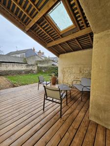 un patio con 2 sillas y una mesa en una terraza de madera en Le refuge de Loire, en Montrelais