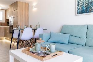ein Wohnzimmer mit einem blauen Sofa und einem Tisch in der Unterkunft Luxury Parque Santiago I in Playa de las Americas