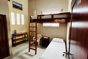 a bedroom with a bunk bed and a desk and a bunk bed at Casa #344 - Habitación 2 - Twin & Bunk Bed - NO AC in Puerto Ayora