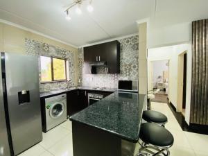 - une cuisine avec un comptoir noir et un lave-vaisselle dans l'établissement Siena Sun Apartment 8, à Midrand 19 autres photos