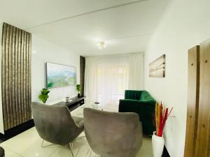 un salon avec deux chaises et un canapé dans l'établissement Siena Sun Apartment 8, à Midrand