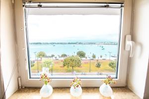 three white vases sitting in front of a large window at Apartment Umag Center Istria Croatia in Umag