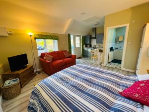 um quarto com uma cama grande e um sofá vermelho em Pentre Cerrig Country House em Llanferres