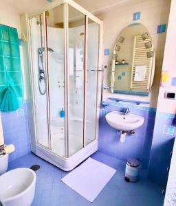 a blue tiled bathroom with a shower and a sink at Salotto Napoletano 381 in Naples
