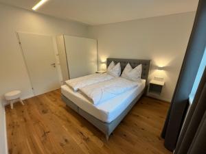 a bedroom with a bed with white sheets and pillows at Ferienwohnung Jäger Veronika in Altenmarkt im Pongau