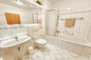 une salle de bain avec un lavabo, des toilettes et une baignoire dans l'établissement Am Schloonsee Haus B, à Heringsdorf 37 autres photos