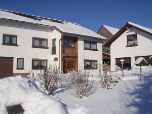 una casa con nieve delante en Ferienwohnung Martina, en Medebach