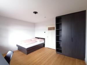 a bedroom with a bed and a black cabinet at Alter Bahnhof Ortenberg in Ortenberg