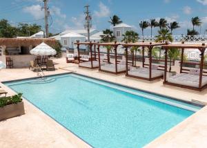 a swimming pool with chairs and an umbrella on a resort at Parguera Plaza Hotel - Adults Only in La Parguera